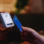 a person holding a credit card and a cell phone global payments, currencies, secure transaction