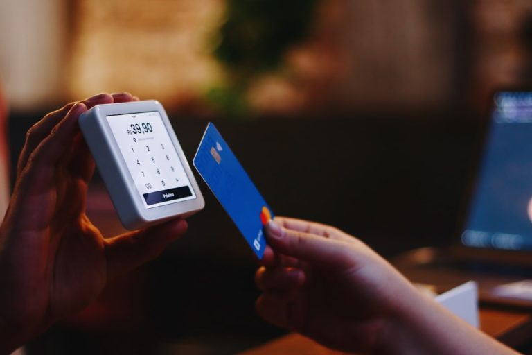 a person holding a credit card and a cell phone global payments, currencies, secure transaction