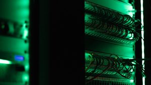 a rack of electronic equipment in a dark room web hosting, server room, website setup