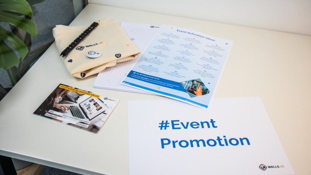 a table with a brochure, magazine, and pen on it event flyers, invitation design, promotional materials