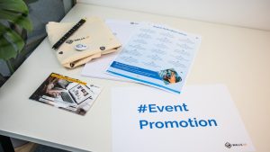 a table with a brochure, magazine, and pen on it event flyers, invitation design, promotional materials