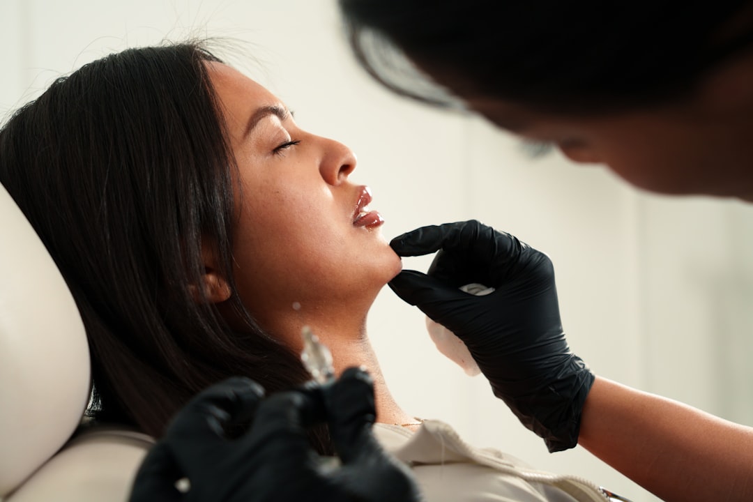 A woman receiving a cosmetic injection on her chin. doctor tablet, patient consultation, aesthetic clinic
