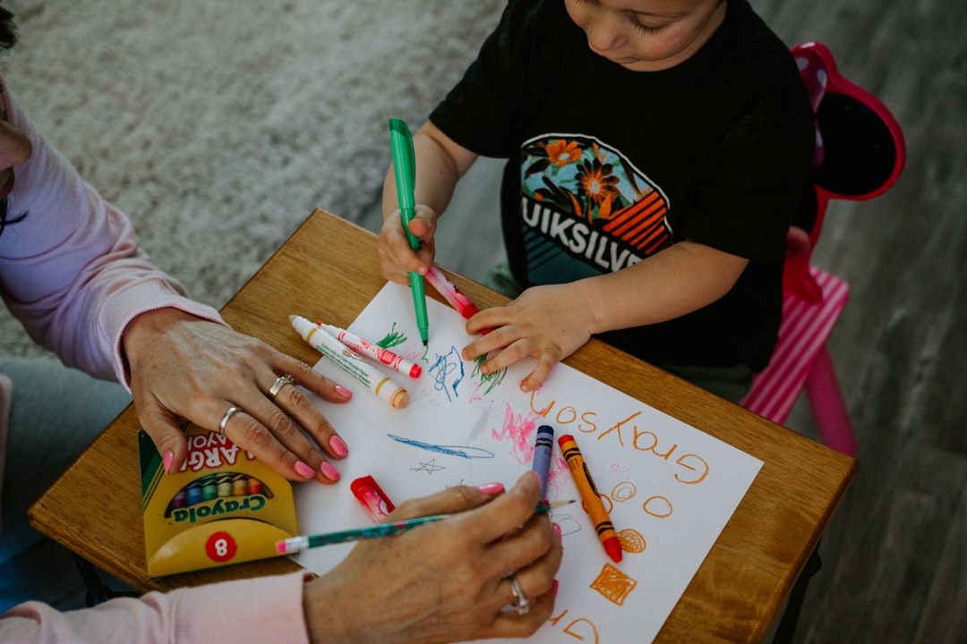 boy in black crew neck t-shirt holding green pen diverse families, support resources, accessible materials