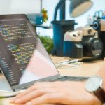 gray laptop computer on brown wooden desk code editor, machine learning assistant, software project, productivity