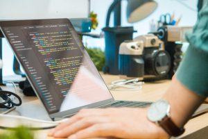 gray laptop computer on brown wooden desk code editor, machine learning assistant, software project, productivity