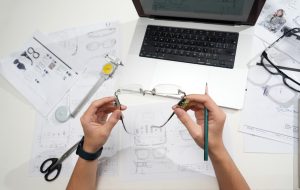 Hands holding glasses over design blueprints cad model, online quote, engineering workspace