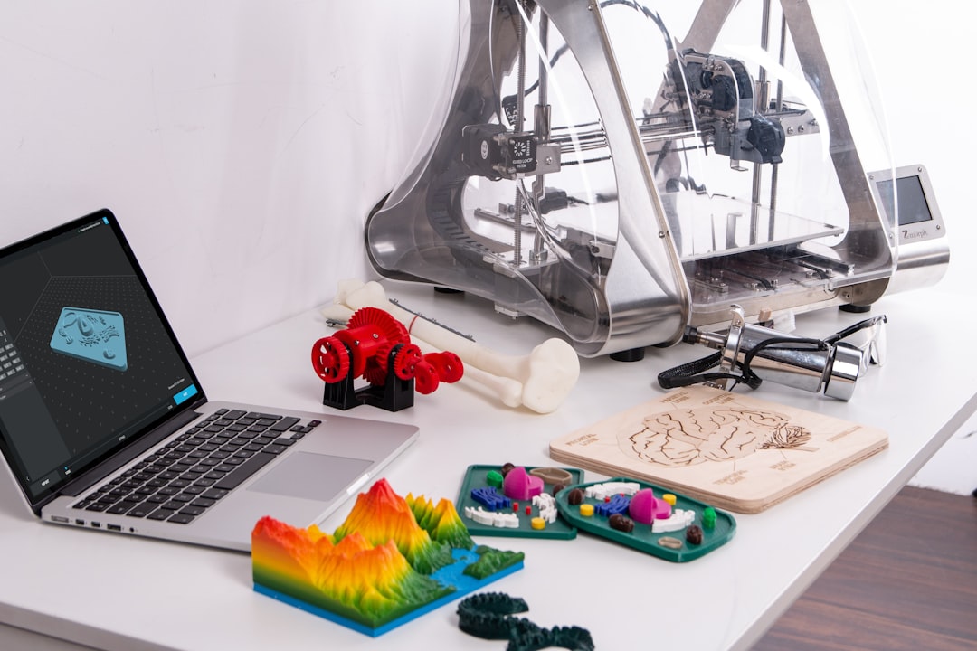 MacBook Pro beside 3D printer finished 3d printed parts, quality inspection, precision tools