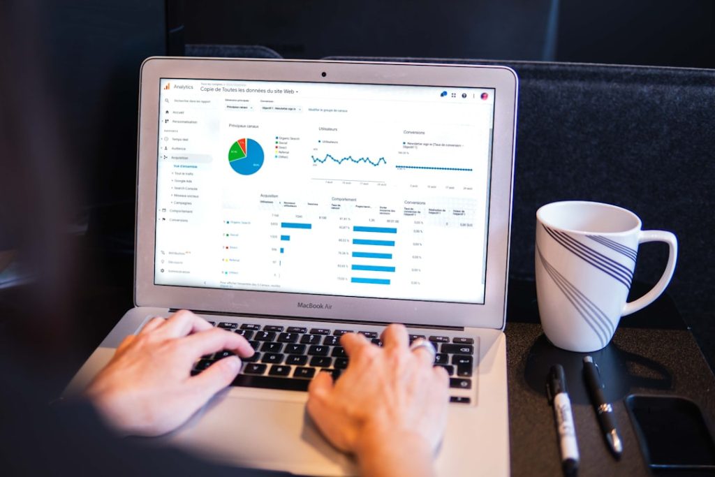 person using macbook pro on black table data team, workshop session, laptop dashboards