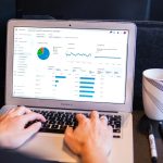 person using macbook pro on black table data team, workshop session, laptop dashboards
