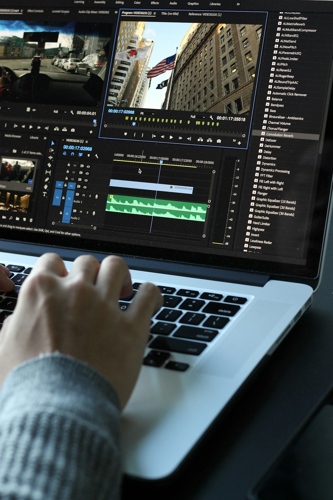 person using MacBook pro turned on video production, filmmaker, online portfolio