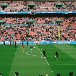 Soccer players warming up on a field in a stadium. soccer team, jerseys, stadium, team spirit