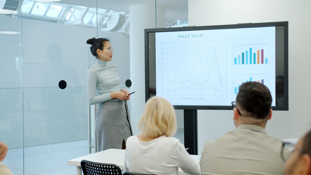 Woman presenting a graph to an audience conference stage, keynote speaker, business analytics