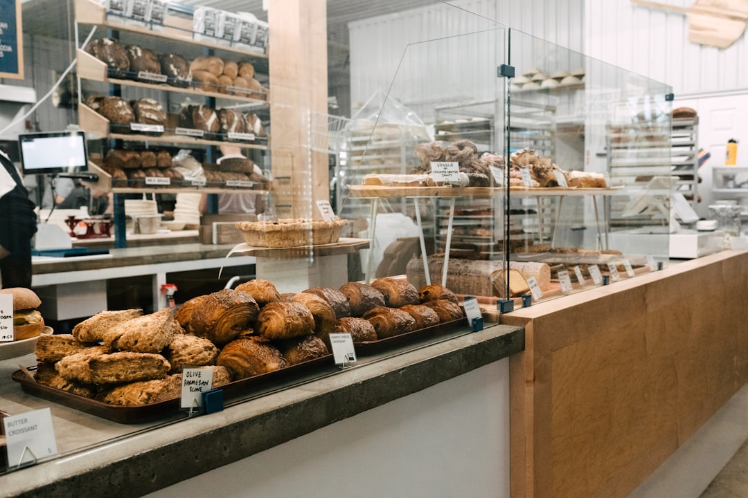 a bakery filled with lots of baked goods small shop owner, bakery counter, friendly business