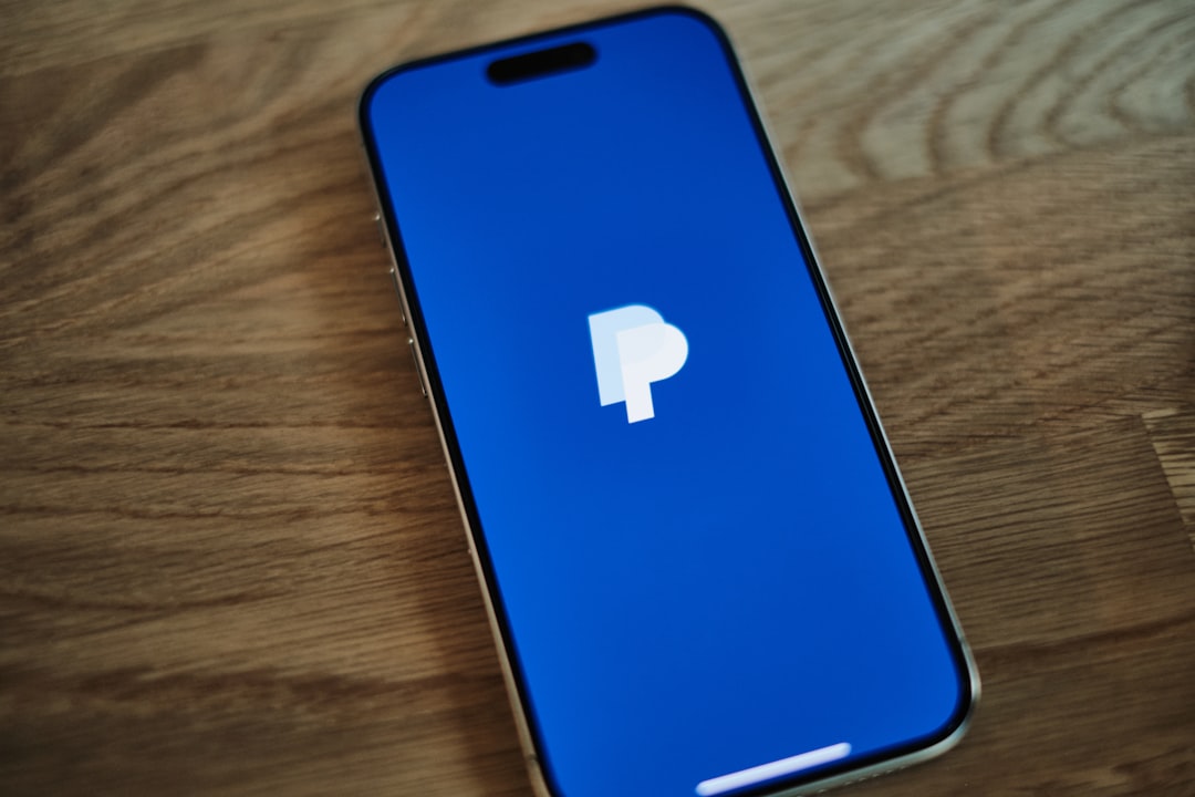 A blue iPhone sitting on top of a wooden table paypal dashboard, order tracking, ecommerce shipment