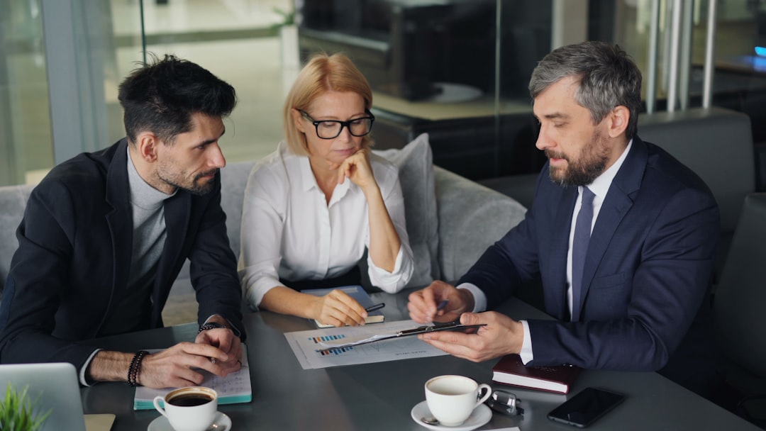 a group of people sitting around a table audit meeting, compliance documents, office discussion