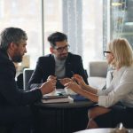 a group of people sitting around a table business meeting, professional services, client trust