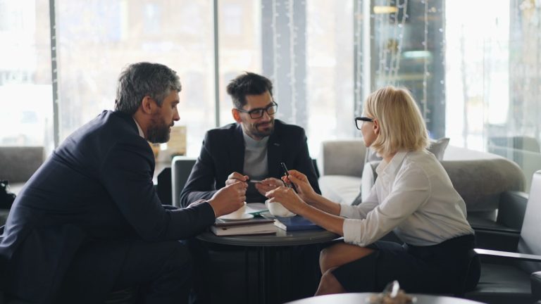 a group of people sitting around a table business meeting, professional services, client trust