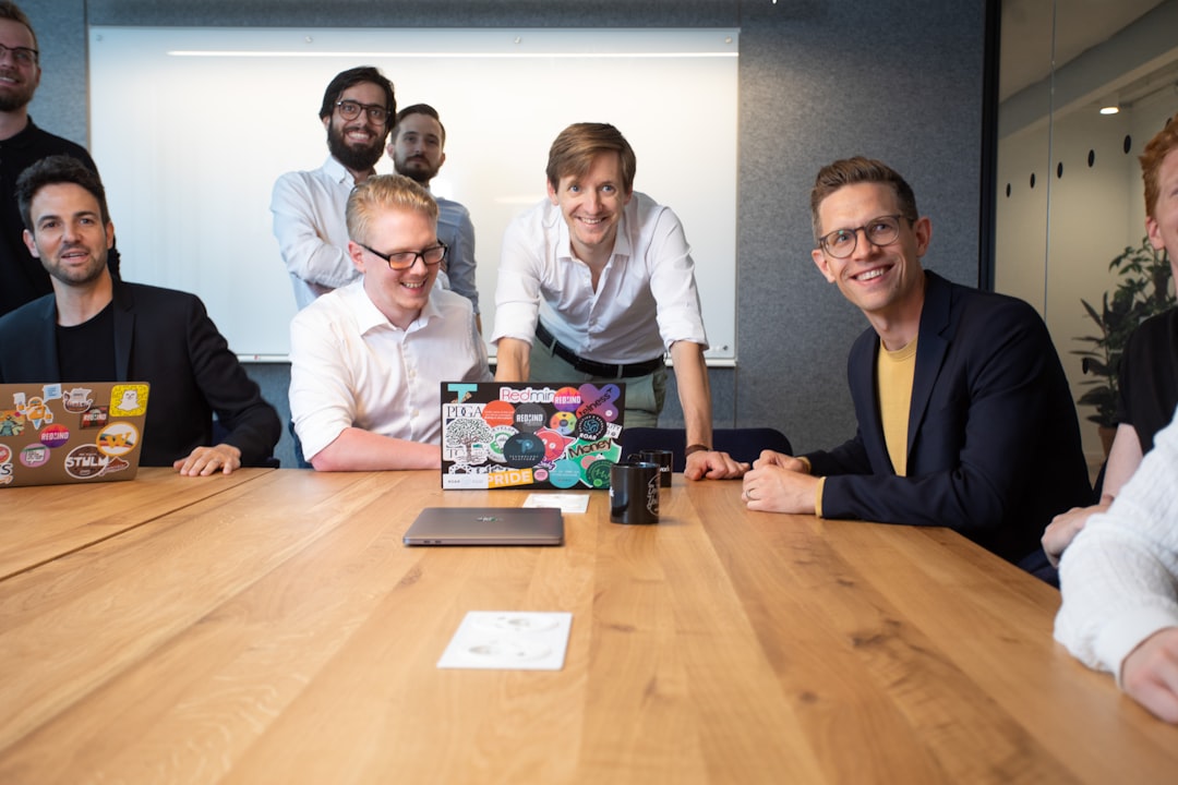 a group of people sitting around a wooden table founders, ecommerce team, planning board