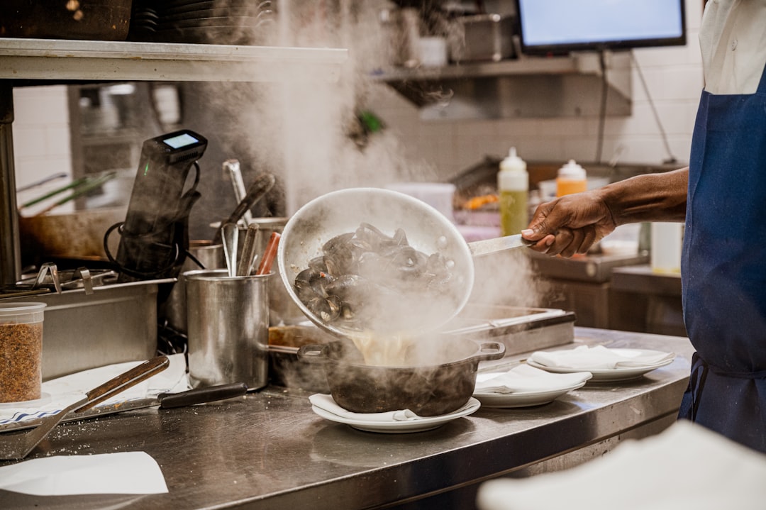 a person in a kitchen cooking food on a stove kitchen display, restaurant orders, chefs, indian food