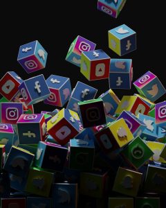 a pile of colorful cubes with social icons flying out of them social media ads, product videos, competitor analysis