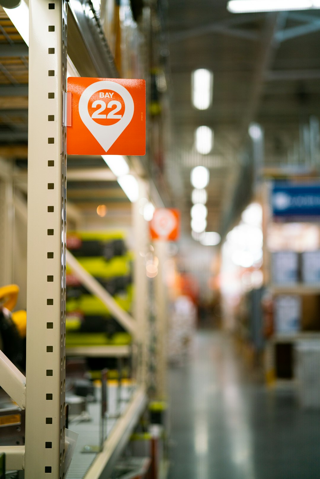 a sign that is on a shelf in a store warehouse shelves, packing boxes, shipping labels