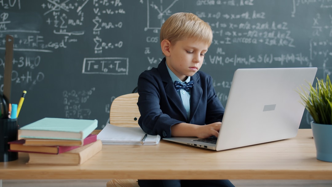 Boy in suit using laptop in classroom teacher laptop, gradebook, classroom
