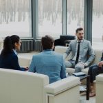 Four professionals in a modern office meeting space. workplace conversation, professional discussion, calm meeting