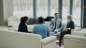 Four professionals in a modern office meeting space. workplace conversation, professional discussion, calm meeting