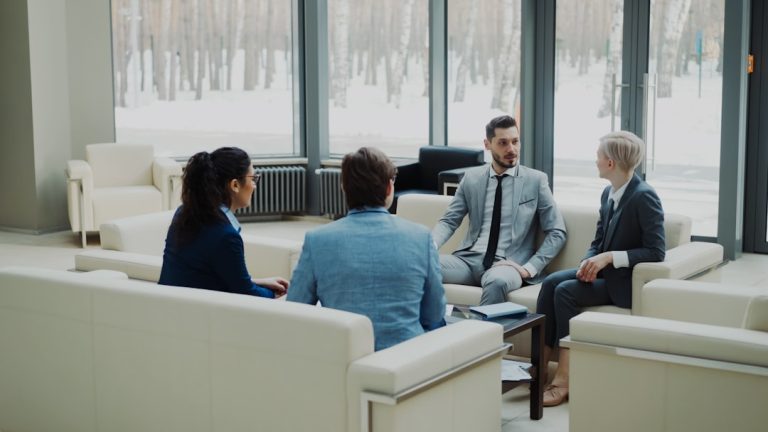 Four professionals in a modern office meeting space. workplace conversation, professional discussion, calm meeting