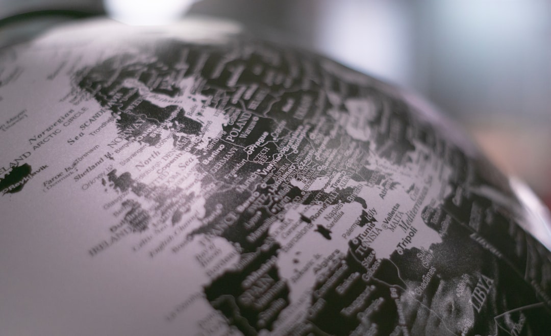 grayscale photo of desk globe global patents, world map, intellectual property