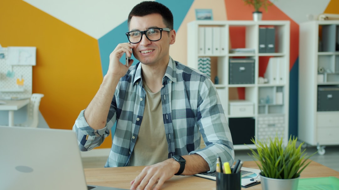 Man in glasses talking on phone at desk admin audit, connected services, workspace security