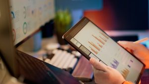 Someone analyzes financial data on a tablet. mobile advertising, user engagement, app analytics