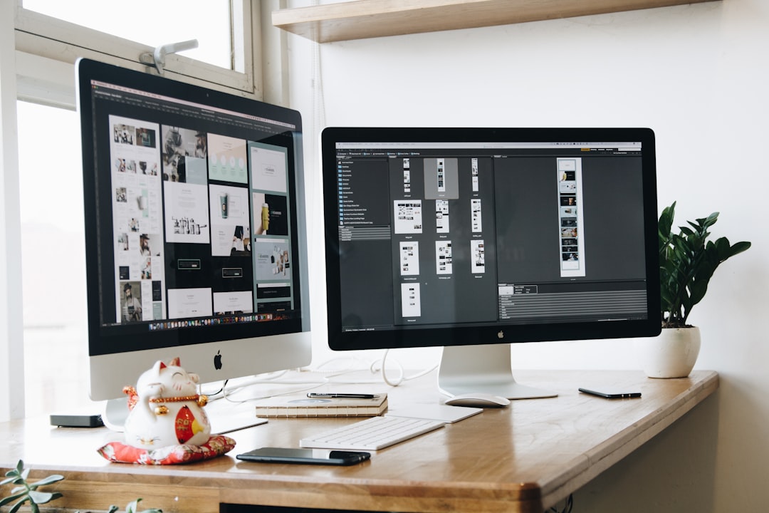 two computer monitors sitting on top of a wooden desk software comparison, creative tools, design alternatives