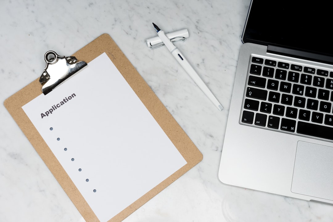 white paper on brown folder beside silver laptop computer automation checklist, payment confirmation, subscriber sequence