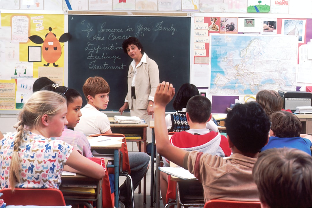 woman standing in front of children students classroom teacher books