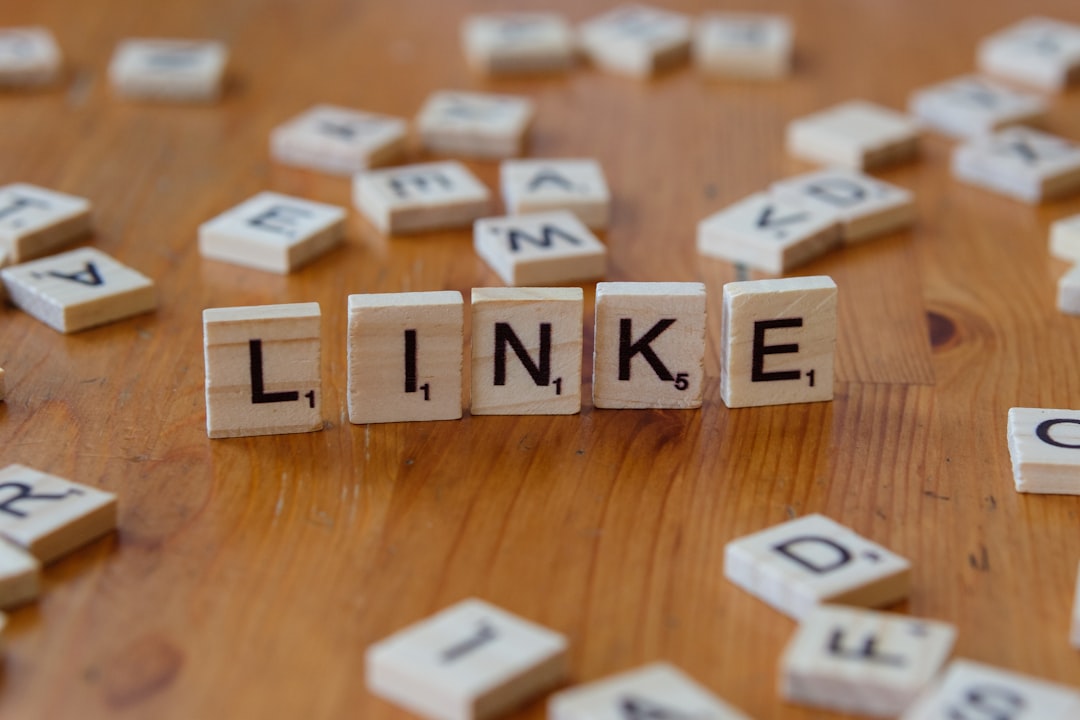 A wooden table topped with scrabble tiles spelling the word link backlink profile, anchor text, spam links