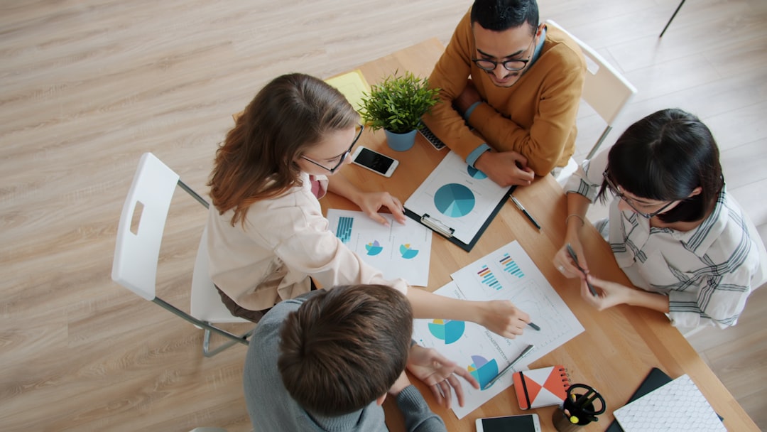 Diverse team collaborating around a table with charts workforce analytics, hr planning, employee performance