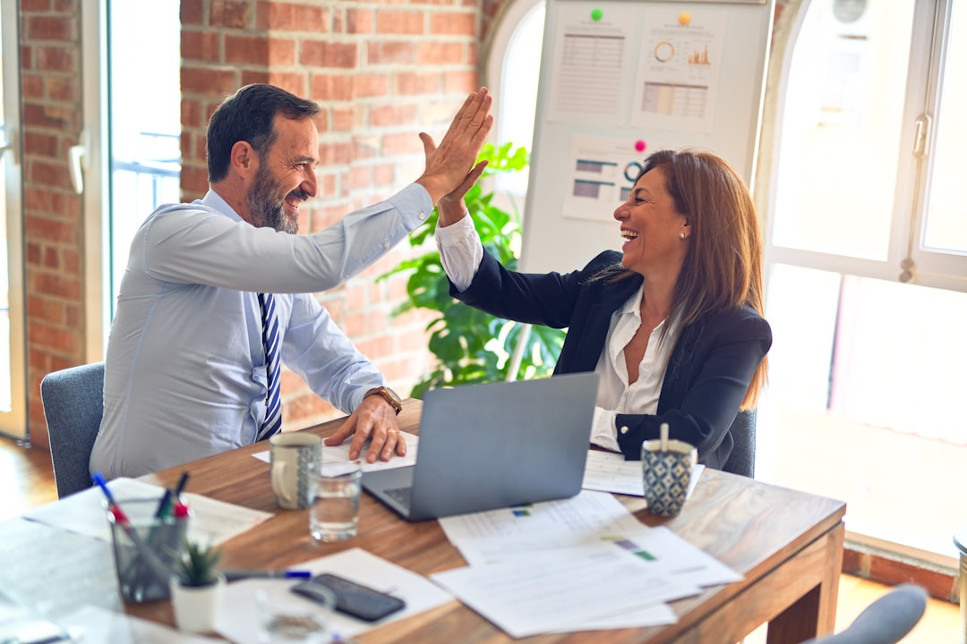 man in white dress shirt sitting beside woman in black long sleeve shirt career growth, project management, office success