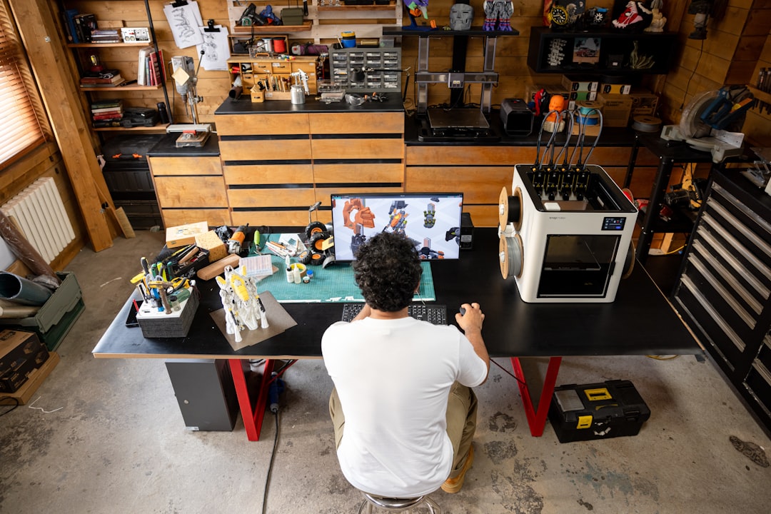 Man working at a desk with 3D printer. cad comparison, drafting software, design tools