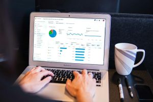 person using macbook pro on black table email report, conversion funnel, marketing metrics