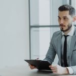 Two people in a business meeting with a clipboard. sales interview, hiring manager, confident candidate
