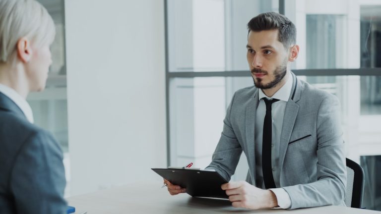 Two people in a business meeting with a clipboard. sales interview, hiring manager, confident candidate