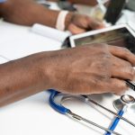 a close-up of a hand on a laptop healthcare privacy, secure data, medical compliance