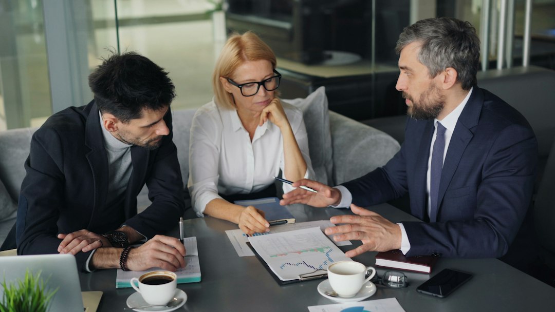 a group of people sitting around a table executive meeting, kpi report, business intelligence, performance review