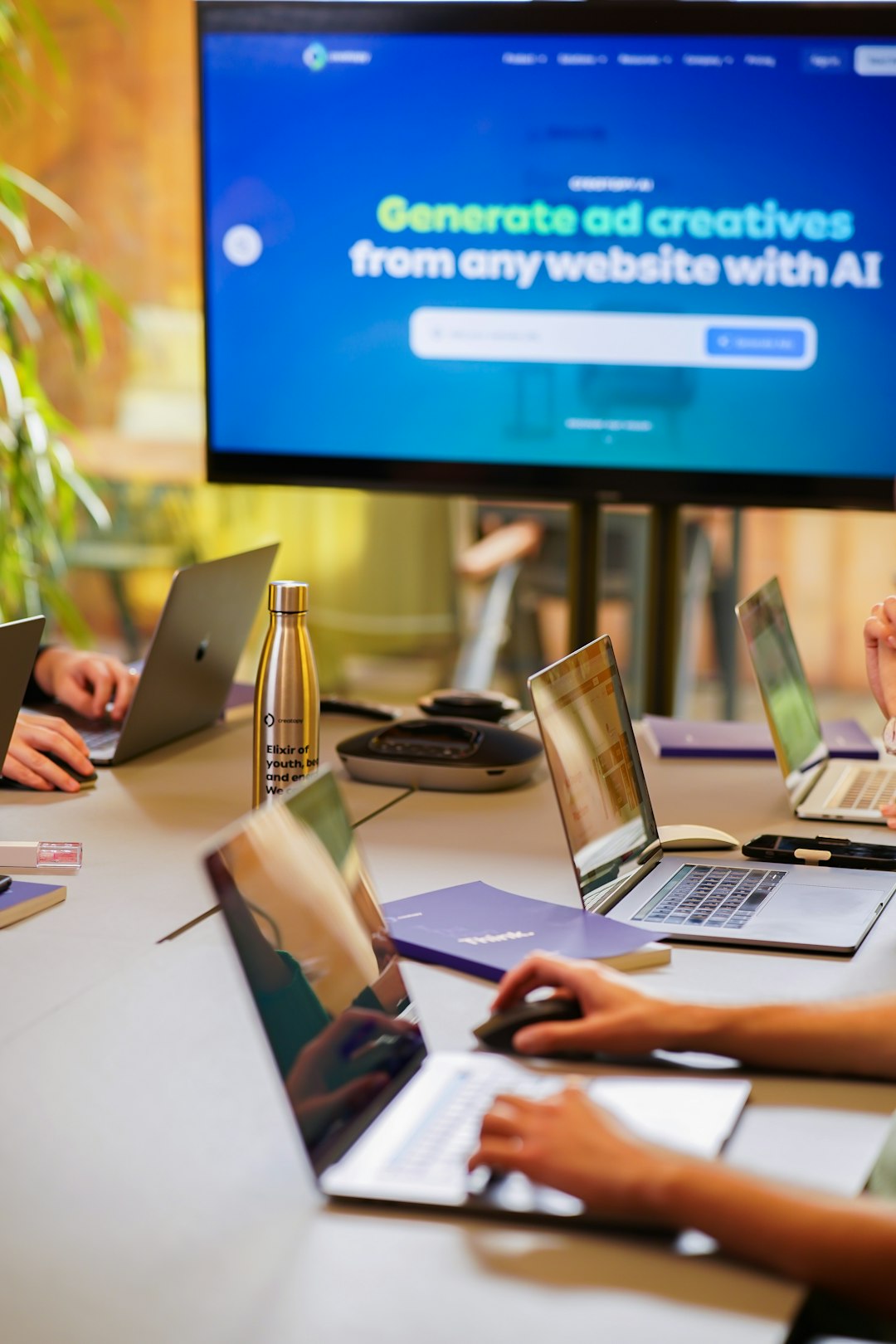 a group of people sitting around a table with laptops agency team, client websites, maintenance workflow, support tickets