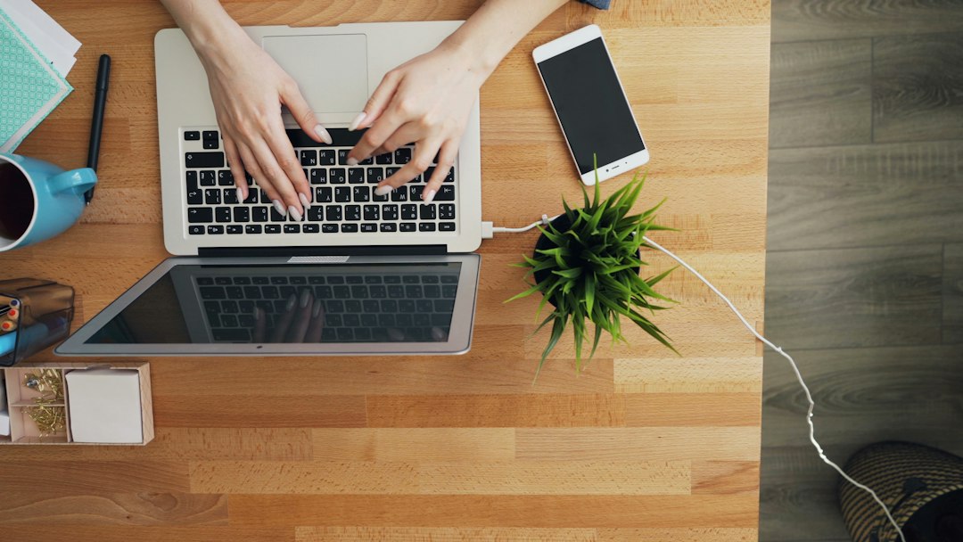 a person typing on a laptop on a wooden table newsletter editor, writer desk, audience growth