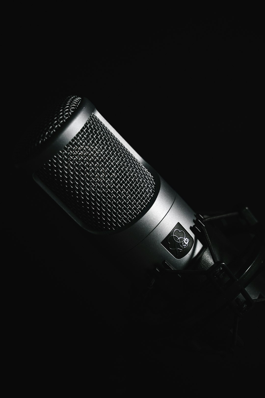 black microphone on black background audio editing, waveform, voiceover microphone