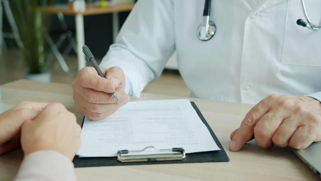 Doctor writing on a patient's chart patient visit, ambient recording, clinical notes