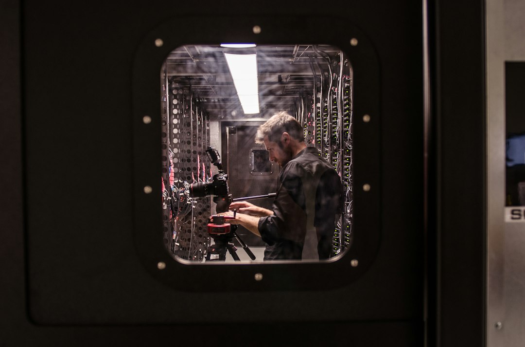 man holding black DSLR camera engineer laptop, automation cabinet, technical manual