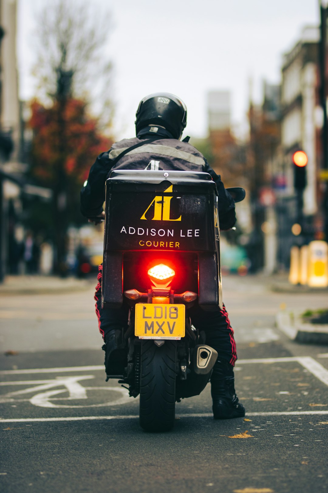 man in black helmet and black jacket with helmet on road during daytime order tracking, delivery scooter, mobile notification